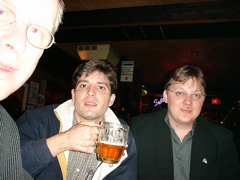 Abends in einer Bar: ein Mann mit Bierglas, rechts daneben Andreas Lindenblatt.