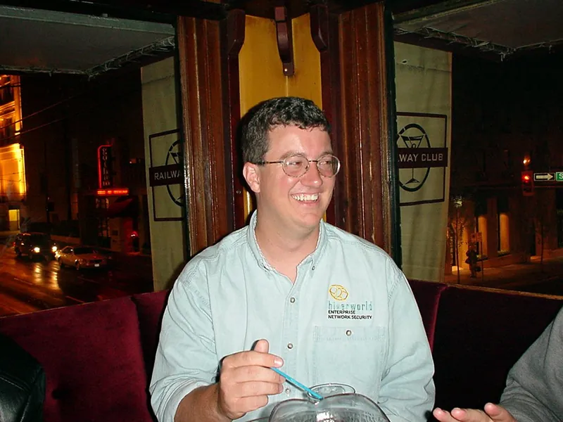 Marty Roesch lacht an einem Tisch in einer Bar.